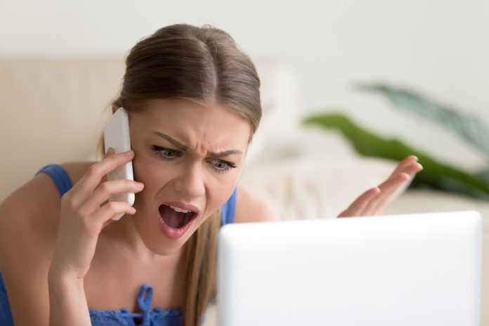 Angry dissatisfied young woman calling customer support, arguing on phone ENELX