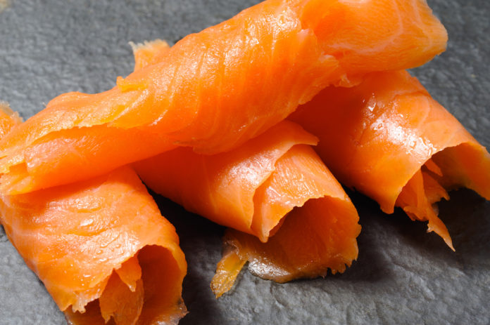Close-up of rolls of smoked salmon on a gray background Salmone listeria