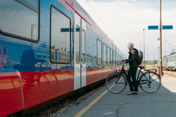 mature-woman-with-bicycle-on-a-public-transport-picture-id530938818