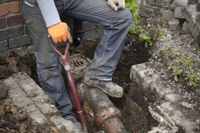 Builder Repairing Sewerage Pipe On Site FOGNATURA