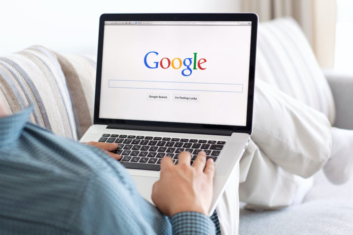 man sitting the MacBook retina with site Google on screen google