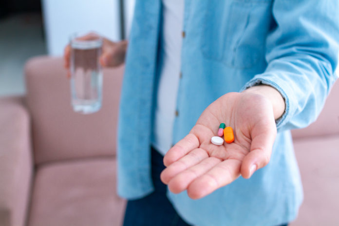 Vitamins and tablets for well-being and disease treatment. Medicine woman taking pills for wellness. Health care lattoferrina