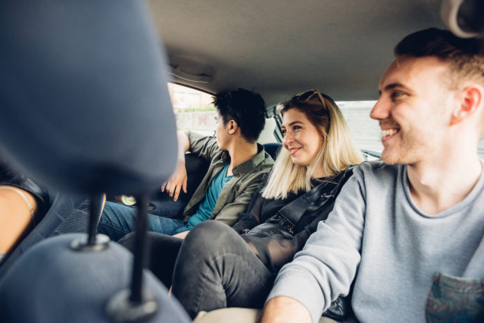 Group of friends multiethnic millennials view from automobile window traveling by car - togetherness, interaction, car sharing concept car pooling