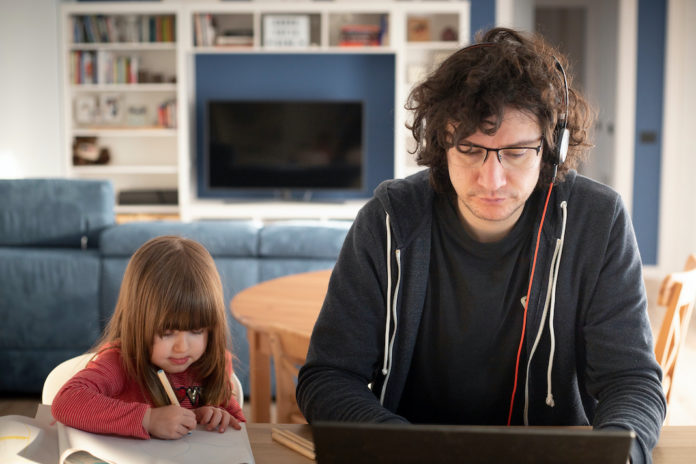 Father working from home with little daughter during covid-19 lockdown. smartworking