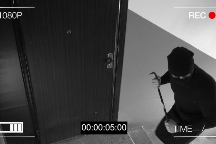 See CCTV as a burglar breaking in through the door with a crowbar FURTO IN CASA