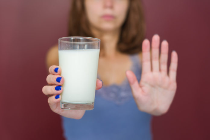 Ótimo conceito de intolerância a lactose, leite. Jovem mulher negando copo de leite. ALLERGIE INTOLLERANZE