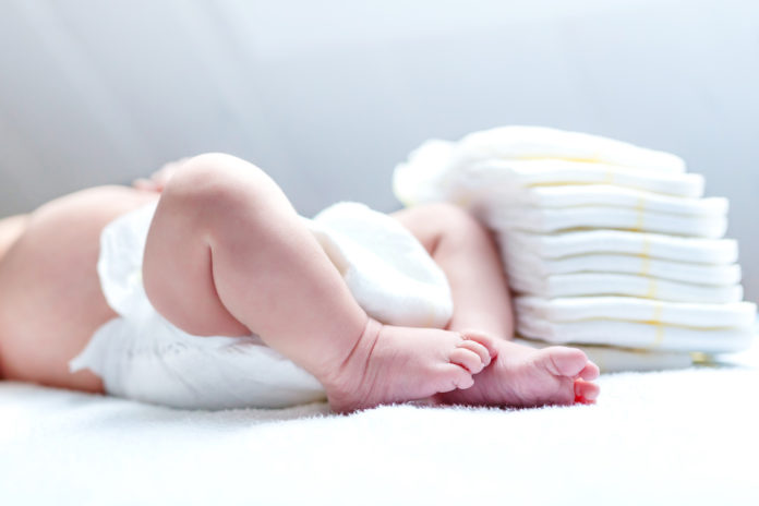 Feet of newborn baby on changing table with diapers DERMATITE DA PANNOLINO