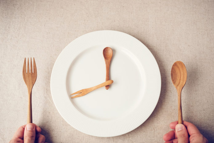 white plate with spoon and fork, Intermittent fasting concept, ketogenic diet, weight loss DIGIUNO INTERMITTENTE