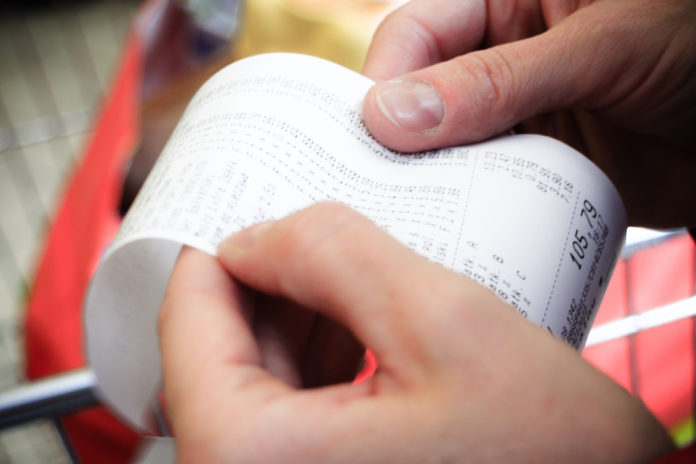 Supermarket. paper check receipt bill in hand. discount prezzi