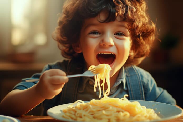 Happy child eating fresh cooked health meal with noodles. Generative Ai. MICOTOSSINE PASTA