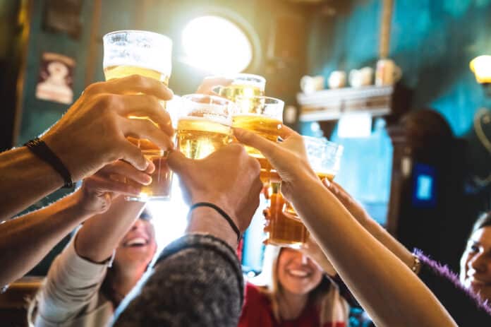 rumore Group of happy friends drinking and toasting beer at brewery bar restaurant - Friendship concept with young people having fun together at cool vintage pub - Focus on middle pint glass - High iso image rumore