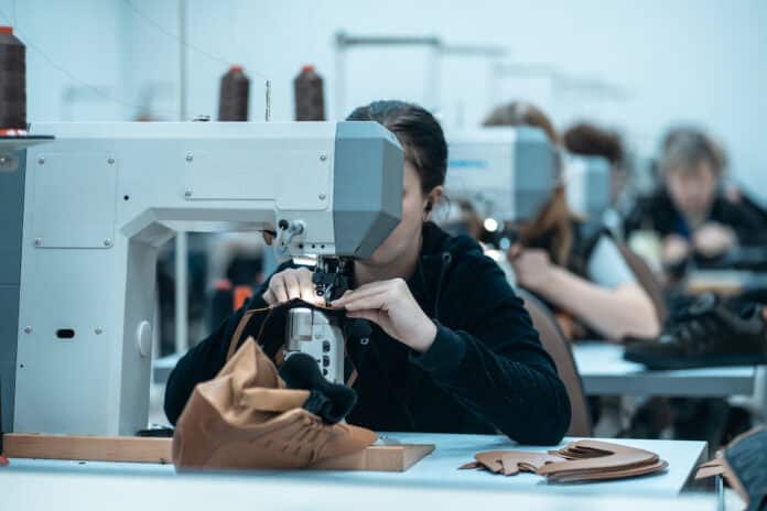 woman work with sewing machinery on shoe factory UIGURI XINJIANG
