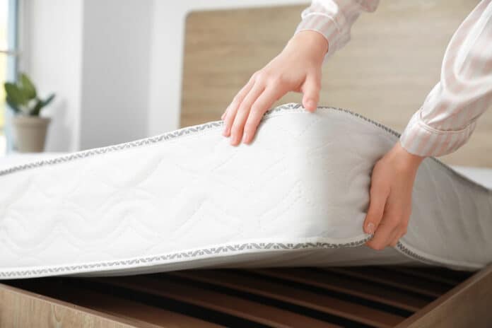 materassi Woman putting soft orthopedic mattress on bed materassi