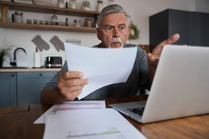 Senior shocked man paying bills online. Documents prepare special for shoot. BOLLETTA