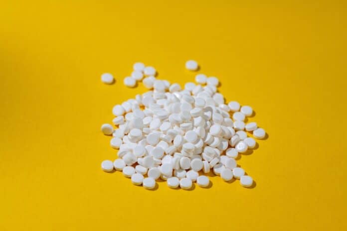 Sugar substitute, sweetener pills over yellow background. Food supplement. Diabetic, over weight, health concept. dolcificanti, sucralosio