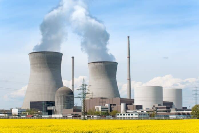 Nuclear power Energy concept - Nuclear power plant with yellow field and big blue clouds. Nuclear power plant in Germany nucleare
