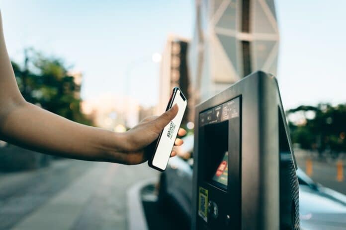 Business woman paying for parking using mobile phone QR CODE