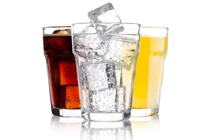 Glasses of cola and orange soda drink and lemonade PFAS