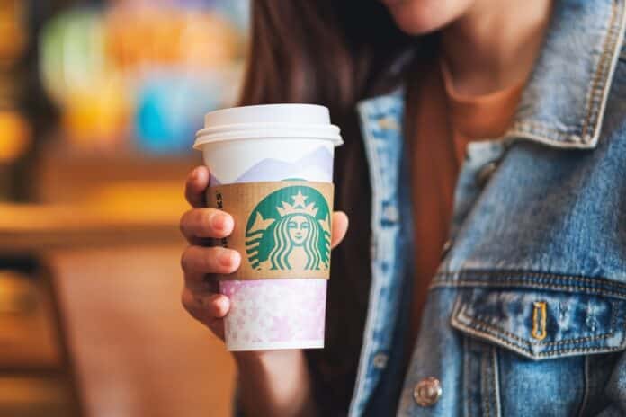 Jun 20th 2020 : Close up of a woman holding a paper cup of coffee at Starbucks coffee shop , Chiang mai Thailand CAFFÈ CAFFEINA