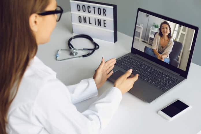 TELEVISITA CERTIFICATO DI MALATTIA Online medical consultation. The patient and the doctor are talking to the web conferencing on the laptop remotely. Virtual clinic concept. TELEVISITA CERTIFICATO DI MALATTIA