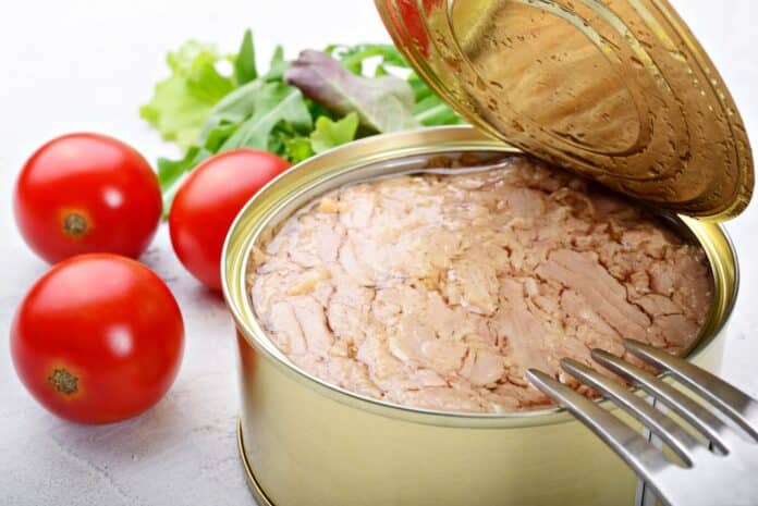 Canned tuna in olive oil with tomatoes and salad on white plaster background TONNO MERCURIO