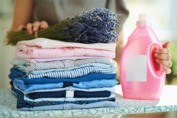 woman with ironing board, clothes, softener and lavender AMMORBIDENTE