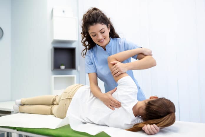 Physiotherapist treatment patient. Holding patient's hand, shoulder joint treatment. Physical Doctor consulting with patient About Shoulder muscule pain problems Physical therapy diagnosing concept