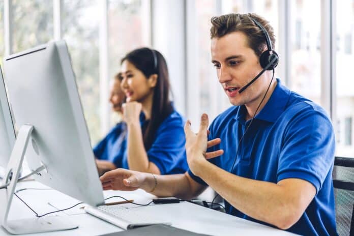Group of happy call center smiling business operator customer support team phone services agen working and talking with headset on desktop computer at call center call center telemarketing