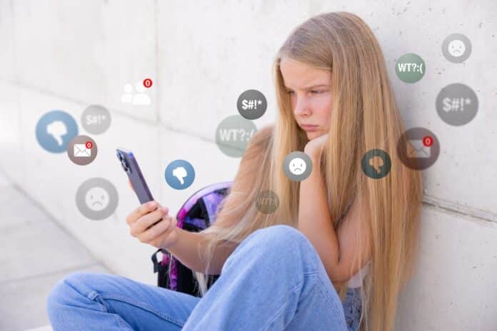 Sad girl viewing negative reactions and comments on social media, concept of children online bullying. divieto social bambini