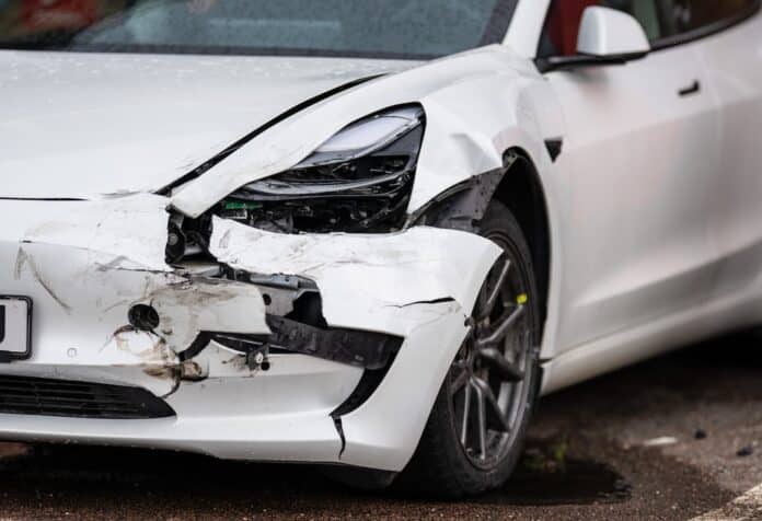 Crashed white electric car waiting for repair. auto elettrica rc auto