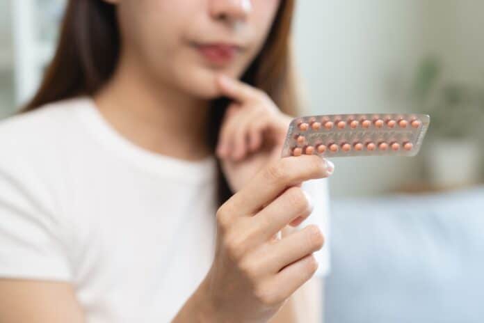 young female holding birth control pills ANTICONCEZIONALI